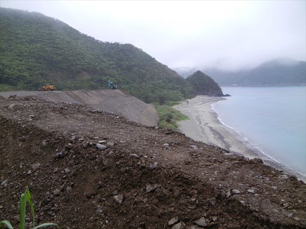 海岸に積み上げられた土砂の山とショベルカー