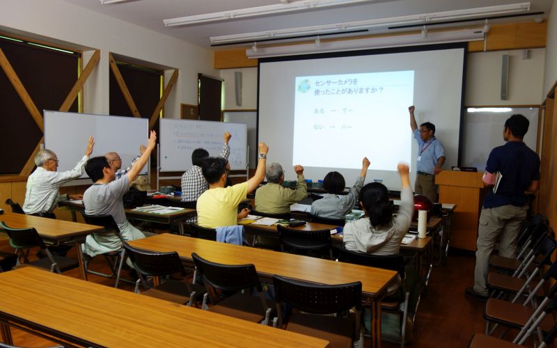 室内で講義で受ける哺乳類調査チーム（写真）