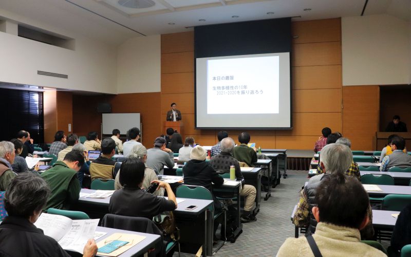 会議壇上で講義する道家の写真