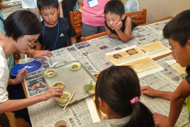 作り方を学ぶ子供達の写真