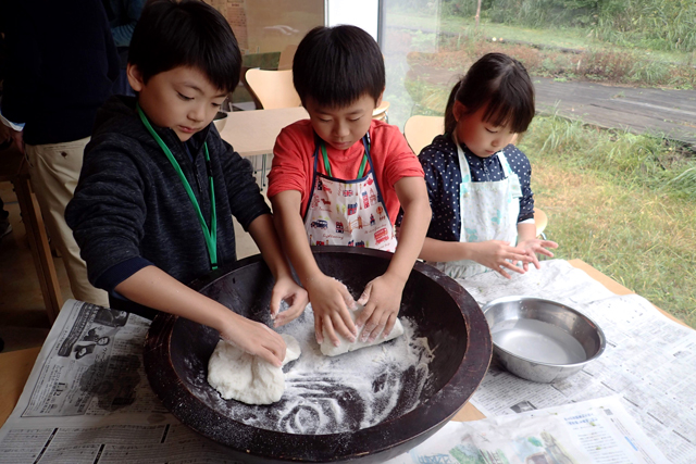 鉢に入れた米粉をこねる子供の写真