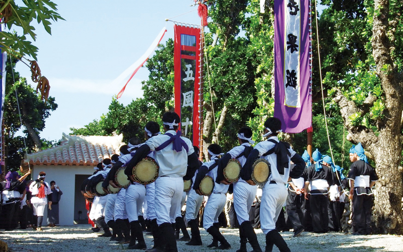 白装束を着た集団が太鼓を叩く白保集落の豊年祭の写真