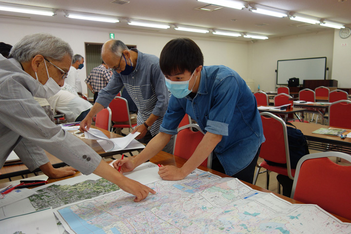 参加者と地図を見る黒島綜一郎さんの写真