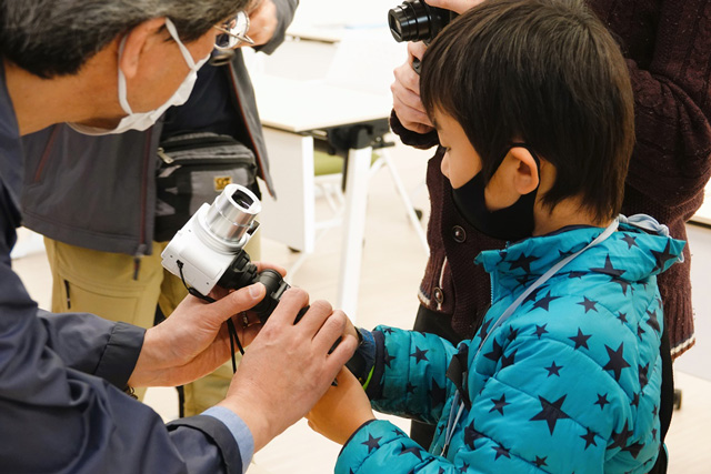 カメラの使い方を学ぶ子どもの写真