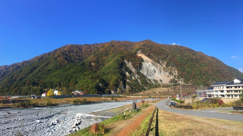 紅葉に色づいた山を正面に大鹿村の風景写真