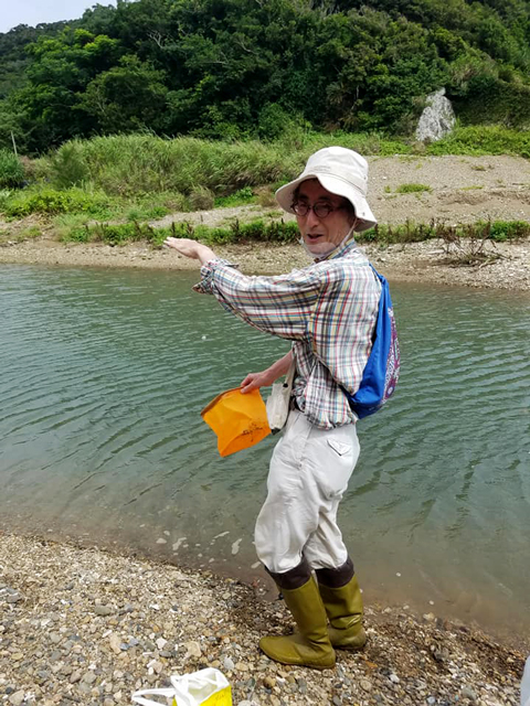 川を案内する佐藤先生の写真