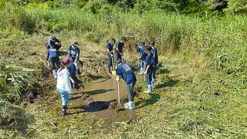スコップで掘り返す生徒の画像