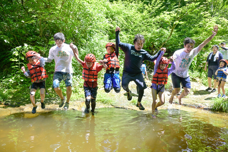 手をつないで川に飛び込む人たちの写真