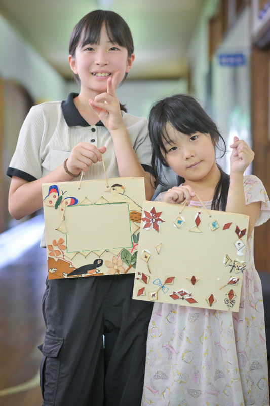 完成した作品を持つ子どもの写真