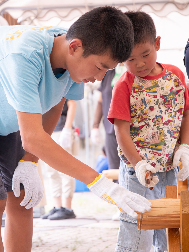 丸太切りに挑戦する子どもの画像