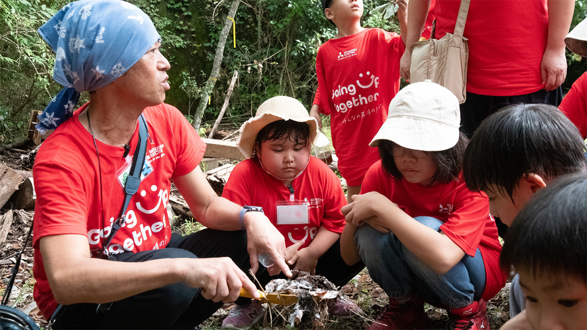 土の教室で説明を聞く子どもたちの写真
