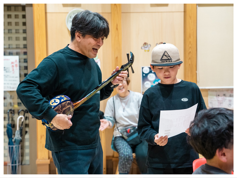 地元の方と島唄を歌う子どもの画像