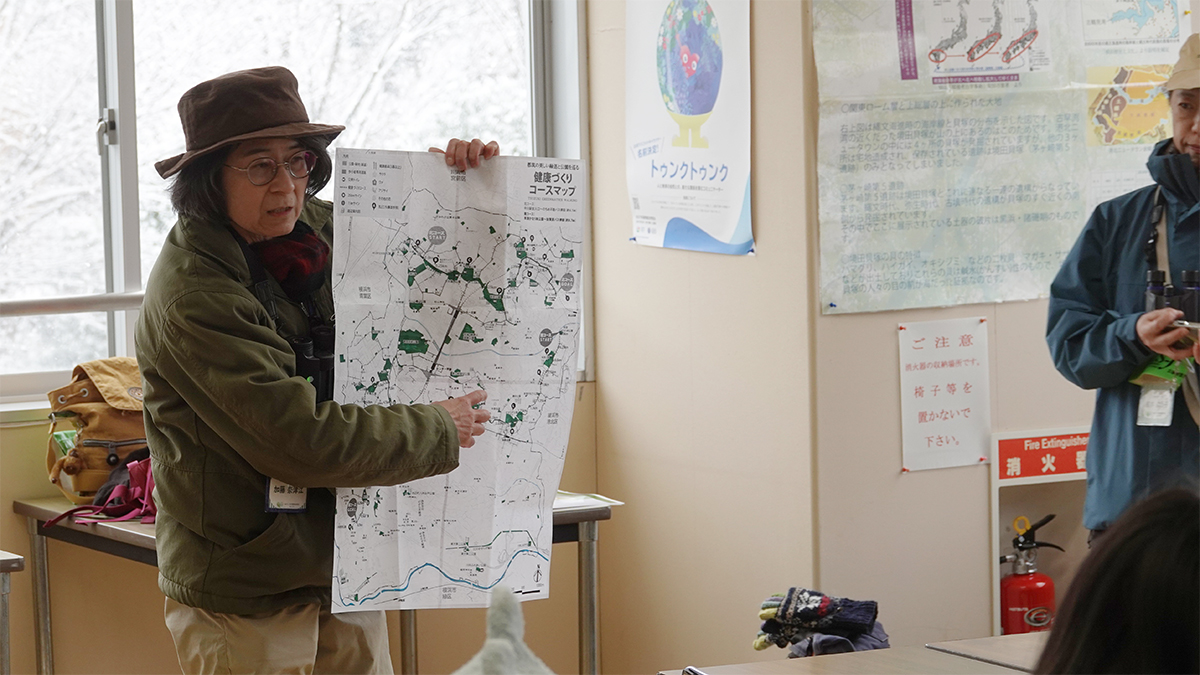 地図を手に説明する人の写真